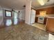 Spacious view into the living room and kitchen with white appliances and oak cabinets at 5650 Kimmerly Woods Dr, Charlotte, NC 28215