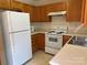 Functional kitchen with oak cabinets, white appliances, and laminate counters at 5650 Kimmerly Woods Dr, Charlotte, NC 28215