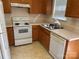 Functional kitchen featuring white appliances, wooden cabinets, and a double stainless steel sink at 5650 Kimmerly Woods Dr, Charlotte, NC 28215