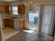 Functional kitchen with oak cabinets, white appliances, and view to patio at 5650 Kimmerly Woods Dr, Charlotte, NC 28215