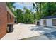 Large, paved backyard with detached shed by a brick house at 5720 Amity Pl, Charlotte, NC 28212