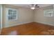Bedroom featuring hardwood flooring, two windows, and a ceiling fan at 5720 Amity Pl, Charlotte, NC 28212