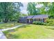 Well-manicured lawn leads to a charming brick home, complemented by a sidewalk and lush hydrangea bushes, creating inviting scenery at 5720 Amity Pl, Charlotte, NC 28212