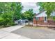 Charming brick home with a black metal fence, mature trees and a driveway at 5720 Amity Pl, Charlotte, NC 28212