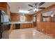 Eat-in kitchen featuring wood cabinets, black appliances, laminate flooring, and a ceiling fan at 5720 Amity Pl, Charlotte, NC 28212