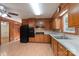 Eat-in kitchen features wood cabinets, black appliances, and laminate countertops at 5720 Amity Pl, Charlotte, NC 28212