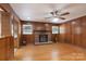 Inviting living room with wood-paneled walls, a brick fireplace, and hardwood floors, creating a warm and classic atmosphere at 5720 Amity Pl, Charlotte, NC 28212