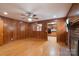 Spacious living room featuring wood paneling, hardwood floors, and a ceiling fan at 5720 Amity Pl, Charlotte, NC 28212