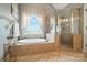 Luxurious bathroom features a large soaking tub with garden window and a separate glass-enclosed shower at 5916 Four Wood Dr, Matthews, NC 28104