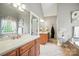 Bathroom featuring double sinks with wood cabinets, large mirror, a soaking tub, and a separate water closet at 5916 Four Wood Dr, Matthews, NC 28104