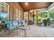Comfortable covered porch with brickwork, outdoor furniture, beverage cooler, and ambient lighting at 5916 Four Wood Dr, Matthews, NC 28104
