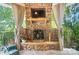 Stone fireplace with a TV, iron gate and decorative accents on a covered porch at 5916 Four Wood Dr, Matthews, NC 28104