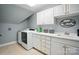 Well-lit laundry room with white cabinets, sink, countertop space, and modern washing machine and dryer at 5916 Four Wood Dr, Matthews, NC 28104