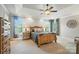 Spacious main bedroom with tray ceiling, large windows, hardwood furniture, and ambient lighting at 5916 Four Wood Dr, Matthews, NC 28104