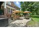Back patio with outdoor kitchen featuring a stone bar, dining area, and professional landscaping at 5916 Four Wood Dr, Matthews, NC 28104