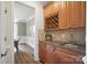 Wet bar with wine rack, granite countertop, sink, and wood cabinets at 5916 Four Wood Dr, Matthews, NC 28104