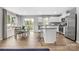Open-concept living and dining area with wood floors, island seating, and stainless steel appliances at 5995 Granbury Dr, Kannapolis, NC 28081
