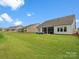 Spacious backyard featuring lush green grass and screened-in porch, perfect for outdoor entertaining at 6020 Waldorf Ave, Monroe, NC 28110