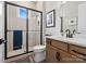 Updated bathroom features a glass shower, stylish fixtures, a wood vanity, and neutral tile at 6020 Waldorf Ave, Monroe, NC 28110
