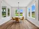 Sunlit dining room with large windows, hardwood floors, and contemporary chandelier at 6020 Waldorf Ave, Monroe, NC 28110