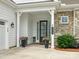 Inviting front porch with elegant columns, decorative planters, and a stylish front door at 6020 Waldorf Ave, Monroe, NC 28110