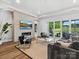 Open-concept living room with tiled fireplace, wall-mounted TV, and sliding glass doors to backyard at 6020 Waldorf Ave, Monroe, NC 28110