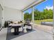 Relaxing covered patio with modern furniture and views of the lush backyard at 6020 Waldorf Ave, Monroe, NC 28110