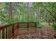 View of wooded lot from newly stained deck with wooden railing and access to trails at 617 Pinecrest St, Davidson, NC 28036
