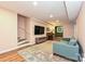 Basement living room featuring comfortable couch, stairs, and hardwood floors at 617 Pinecrest St, Davidson, NC 28036