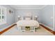 Serene bedroom featuring soft blue walls, a white bed, and natural light from the window at 6422 Northern Red Oak Dr, Mint Hill, NC 28227