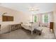 Cozy bedroom features a ceiling fan, plush carpet, and abundant natural light at 6422 Northern Red Oak Dr, Mint Hill, NC 28227
