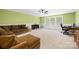 Spacious living room featuring neutral carpet, a ceiling fan, and ample natural light at 6422 Northern Red Oak Dr, Mint Hill, NC 28227