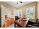 Bright home office featuring hardwood floors, desk, and natural light from white shuttered windows at 6422 Northern Red Oak Dr, Mint Hill, NC 28227