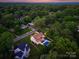 A birds-eye view showcases the home's backyard oasis, featuring a sparkling pool and lush landscaping at 6505 Folger Dr, Charlotte, NC 28270