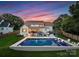 Entertainers backyard with pool, built-in grill, patio seating, and lush landscaping with fence at 6505 Folger Dr, Charlotte, NC 28270
