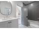 Modern bathroom with a white vanity, silver fixtures, and a gray-tiled shower/tub combination at 6505 Folger Dr, Charlotte, NC 28270