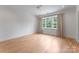 Light-filled bedroom featuring hardwood floors, large windows with curtains, and neutral paint at 6505 Folger Dr, Charlotte, NC 28270
