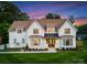 Stunning two-story white brick home with a manicured lawn and beautiful landscaping at 6505 Folger Dr, Charlotte, NC 28270