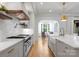 Bright kitchen with hardwood floors, large island, open layout, farm sink, and stainless steel appliances at 6505 Folger Dr, Charlotte, NC 28270