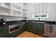 Pantry features open shelves, dark countertops, modern appliances, and hardwood floors at 6505 Folger Dr, Charlotte, NC 28270