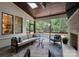 Screened-in patio with comfortable seating, outdoor fireplace, ceiling fan, and view of the pool at 6505 Folger Dr, Charlotte, NC 28270