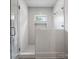 Modern shower with decorative tiling, glass doors, and a built-in niche for storage at 6505 Folger Dr, Charlotte, NC 28270