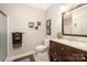 A well-lit bathroom with a vanity, toilet, decorative shelving and tiled shower stall at 676 Cottingham Ne Pl, Concord, NC 28025