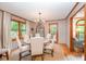 Well-lit dining room with decorative light fixture, neutral walls, hardwood floors, and a large window at 676 Cottingham Ne Pl, Concord, NC 28025