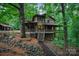 Exterior view of a rustic, wooded home with a wraparound porch at 676 Cottingham Ne Pl, Concord, NC 28025