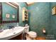 Charming half bathroom featuring unique textured walls, stylish fixtures, and a decorative mirror at 676 Cottingham Ne Pl, Concord, NC 28025