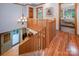 Hallway with a wooden banister overlooking the living room and hardwood floors, showcasing the home's layout at 676 Cottingham Ne Pl, Concord, NC 28025