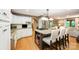 Kitchen featuring hardwood floors, white cabinets, granite counters, stainless steel appliances, and kitchen island at 676 Cottingham Ne Pl, Concord, NC 28025