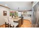 Charming kitchen featuring granite counters, white cabinets, hardwood flooring, and stainless steel appliances at 676 Cottingham Ne Pl, Concord, NC 28025