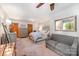 Bright main bedroom features a ceiling fan, neutral carpet, gray sofa, and a coordinating gray upholstered bed at 676 Cottingham Ne Pl, Concord, NC 28025